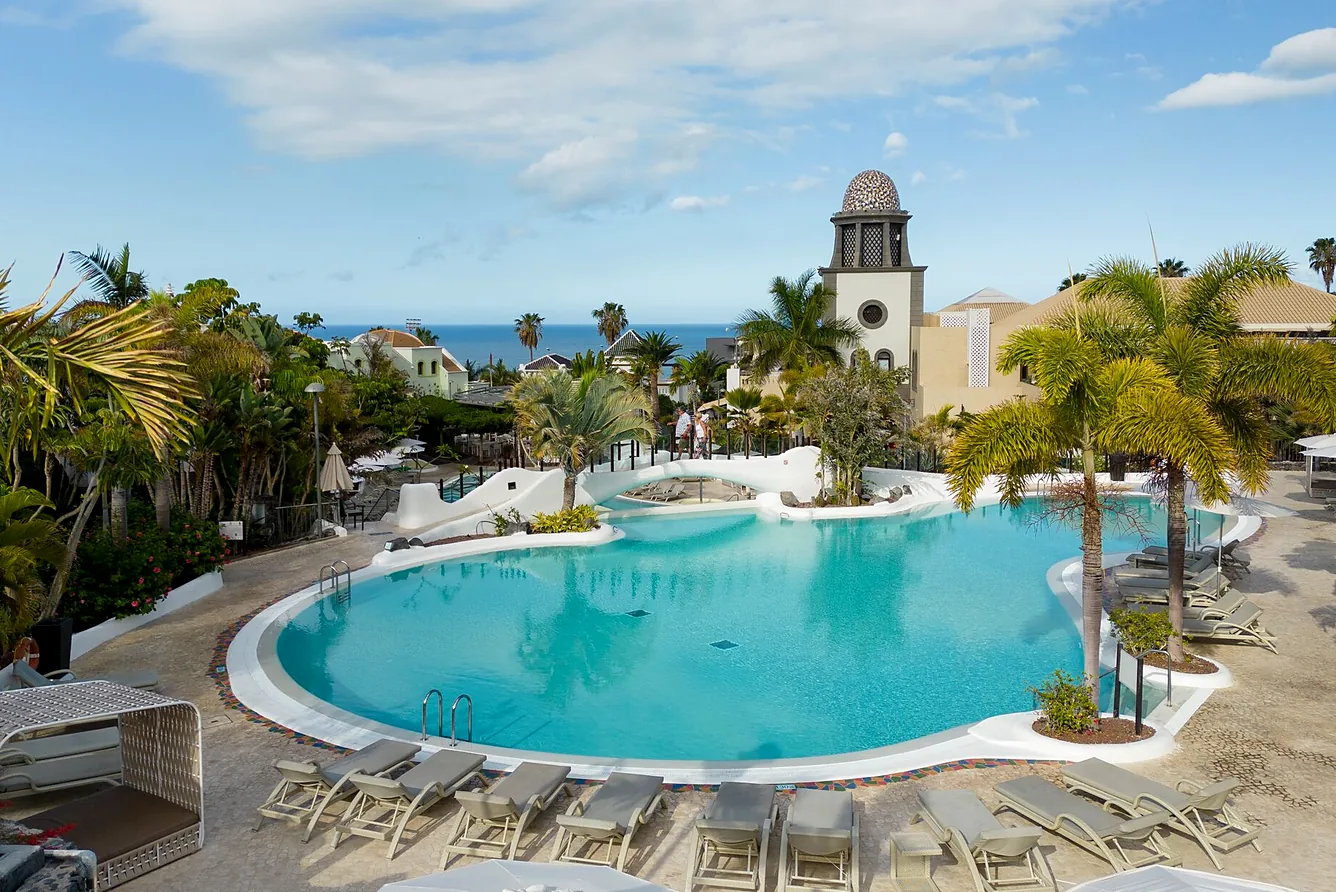 Hotel Suite Villa María 5* - zwembad met ligbedden en de toren van het complex